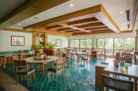 a restaurant with tables and chairs and windows at Maneechan Resort - SHA Extra Plus in Chanthaburi