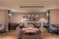 Un restaurante con mesas y sillas y cuadros en la pared. en Aber Abha, en Abha