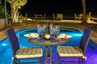 a table with glasses and a bottle of wine next to a pool at Chez Louise et Louis Pé na Areia in Juquei