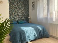 a bedroom with a bed with a blue comforter at Studio cosy avec terrasse, proche Chantiers et Airbus in Saint-Nazaire
