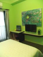 a bedroom with a bed and a desk and a painting at Dreamily Fish B&amp;B in Magong