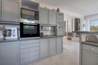 a large kitchen with white cabinets and a microwave at Deconnexion et detente sur la Presqu ile de Rhuys in Le Tour-du-Parc