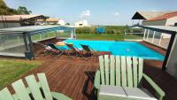 Una terraza con sillas y una mesa y una piscina. en Le Making Of Chambres d&#39;Hôtes insolites et Familiales, en Thairé