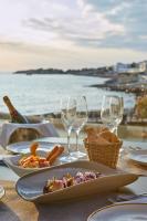 a table with plates of food and wine glasses at Hotel & Spa Blau Parc in San Antonio