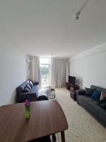 una sala de estar con una mesa y un sofá en Almyria Apartments - By IMH Travel &amp; Tours, en Pafos