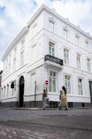 dos personas caminando en frente de un edificio blanco en Hotel du Théâtre, en Brujas