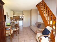 a living room with a couch and a kitchen at Les Jardins d&#39;Ulysse, Pavillon T3, terrasse &amp; parking, Narbonne Plage in Narbonne-Plage