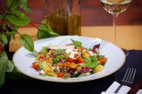 a white plate with a salad on a table with a glass at Hotel Kompleks Beskid z basenem i stokiem narciarskim - blisko Babiej Góry in Spytkowice