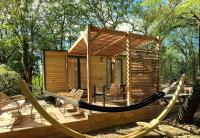 a log cabin with a hammock on a deck at Camping Sunêlia la Clémentine in Cendras