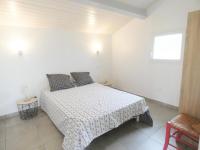 a white bedroom with a bed and a window at Pierron in Linxe