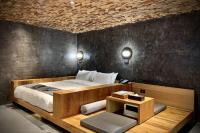 a bedroom with a large bed and a table with a bed sidx sidx at Onsen Papawaqa in Tai&#39;an