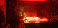 a red bathroom with a tub with lights on it at Cour st Didier in Nevers