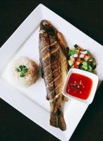 a plate of food with fish and a side of vegetables at Hotel Krishna Kathmandu in Kathmandu
