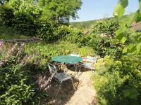 a table and two chairs in a garden at Les chambres de Blanot in Blanot