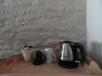 a coffee maker and two mugs on a wooden table at Les chambres de Blanot in Blanot