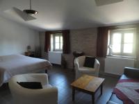 a bedroom with a bed and chairs and a table at Les chambres de Blanot in Blanot