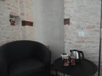 a chair and a table with a tea kettle on it at Les chambres de Blanot in Blanot