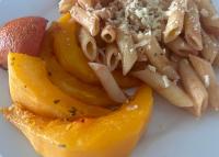 a plate of food with pasta and a papaya at Main Stream Beach Villa in Senga