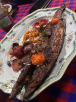 a plate of food with meat and vegetables on a table at Main Stream Beach Villa in Senga