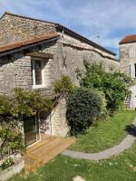 a stone house with a wooden deck in front of it at Le Clos des Grands Frênes in Pons