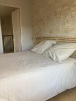 a bed with white sheets and pillows in a bedroom at Le Clos des Grands Frênes in Pons