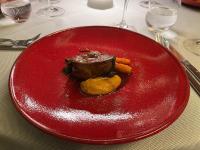 een rood bord met vlees en groenten op een tafel bij Angel Wing Apartamentai in Vilnius