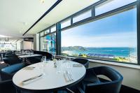 a restaurant with tables and chairs and a large window at L'Agapa Hôtel - Spa Codage in Perros-Guirec