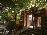 Una entrada a un edificio con escaleras y árboles. en Hotel Murasakimura, en Yomitan