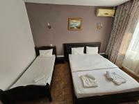- 2 lits dans une petite chambre avec des serviettes dans l&#39;établissement Hotel Jiul, à Eforie Sud