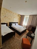Cette chambre comprend 2 lits et une table. dans l&#39;établissement Hotel Jiul, à Eforie Sud