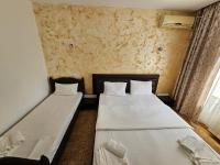 - 2 lits dans une petite chambre avec fenêtre dans l&#39;établissement Hotel Jiul, à Eforie Sud