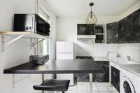 a kitchen with a black table and a microwave at Le Glatigny- Chesnay in Le Chesnay