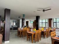 uma sala de jantar com mesas e cadeiras de madeira em HOTEL DEVDAR RESORT em Dharamshala