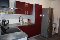 a kitchen with red cabinets and a stainless steel refrigerator at Le petit Gambetta in Belfort