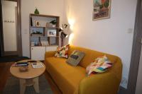 a living room with a yellow couch and a table at Le petit Gambetta in Belfort