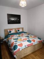 a bed with a colorful comforter in a bedroom at Le petit Gambetta in Belfort
