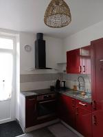 a kitchen with red cabinets and a sink at Le petit Gambetta in Belfort