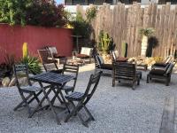 un grupo de sillas y mesas en un patio en Hôtel Les Mimosas, en Argelès-sur-Mer