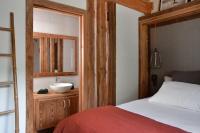 a bedroom with a bed and a bathroom with a sink at Appartement dans chalet de luxe Megève in Megève