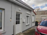 a white house with a car parked in front of it at La petite trapue in Desvres