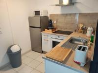 a small kitchen with a sink and a refrigerator at La petite trapue in Desvres