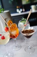 three cocktails in wine glasses on a table at La Métairie De Terrefort in Bouliac