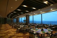 Un comedor con mesas y sillas y grandes ventanales. en Sun Valley Hotel, en Yeoju