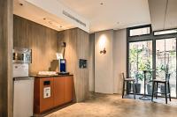 a kitchen with a refrigerator and a counter with a table at Orange Hotel - Ximen, Taipei in Taipei