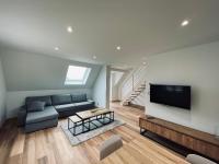 a living room with a couch and a flat screen tv at Gîtes intemporels d&#39;Alsace in Wintzenheim