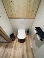 a white toilet in a room with wooden ceilings at Gîtes intemporels d&#39;Alsace in Wintzenheim