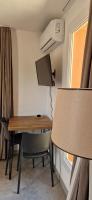 a room with a desk and a table and a lamp at T2 neuf dans résidence avec piscine in Lecci