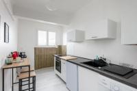 a kitchen with white cabinets and a black counter top at Vue mer &#47; Jaurès-Centre-Ville &#47; Appart Lumineux in Brest