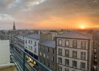 a view of a city at sunset from a balcony at Vue mer &#47; Jaurès-Centre-Ville &#47; Appart Lumineux in Brest