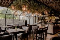 a restaurant with tables and chairs and a bar at Art Suites Luxury Hotel in Kraków